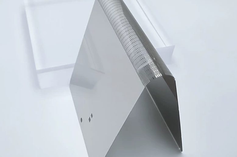 Side view of a thin folded metal support plate showing the precision patterned bending zone