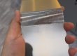 Handheld thin etched metal folding sample showing a dense precision flexible zone