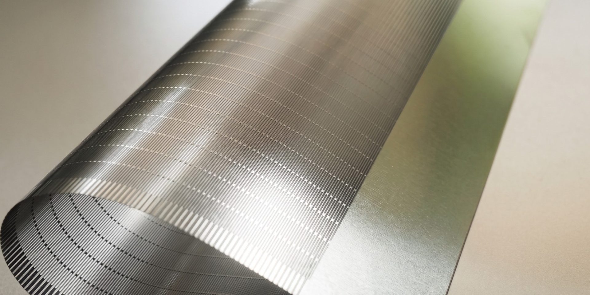 photo-etched-titanium-support-plate-micro-slots Close-up of fine etched micro-slots in a thin titanium support plate for foldable electronics
