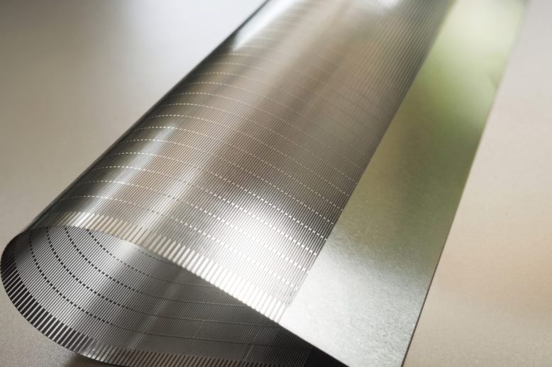 Close-up of fine etched micro-slots in a thin titanium support plate for foldable electronics